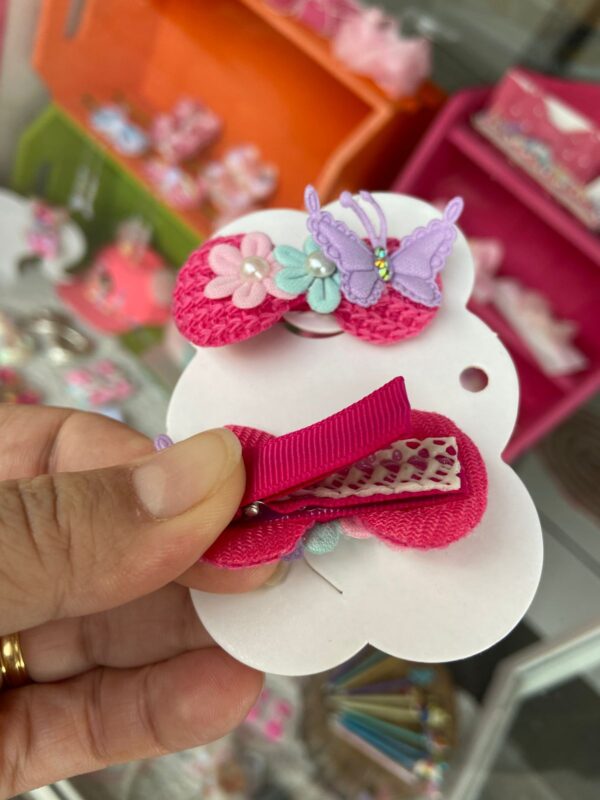 Mini Par de Laço Rosa com Borboletas e flores mostrando a parte do bico de pato com forro anite-deslizante que não machuca a cabeça do bebê