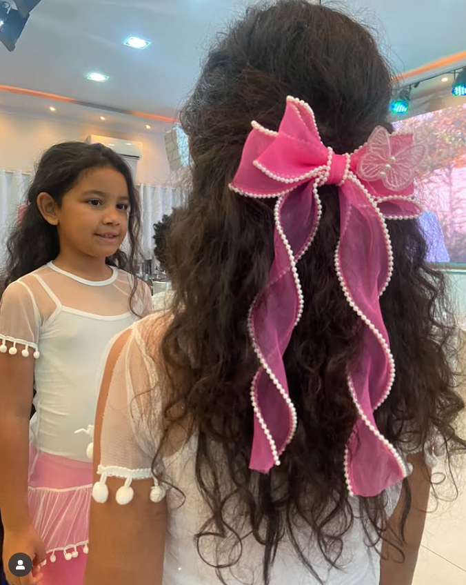 Menina usando um laço rosa.